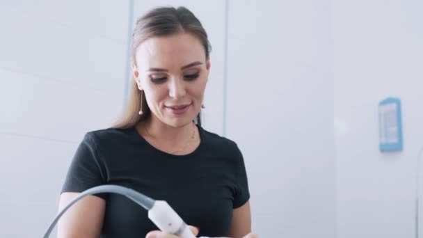 Retrato del cosmetólogo sonriente hace procedimiento de tratamiento facial al paciente, cámara lenta — Vídeos de Stock