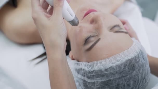 Close-up cosmetoloog handen maakt verjonging procedures op vrouw gezicht in schoonheidssalon, Slow Motion — Stockvideo