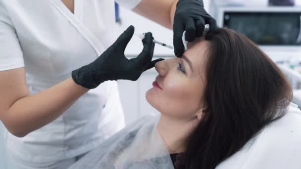 注射器でクローズアップ女性の顔と美容師の手は、顔の美しさの注射、スローモーションを作ります — ストック動画