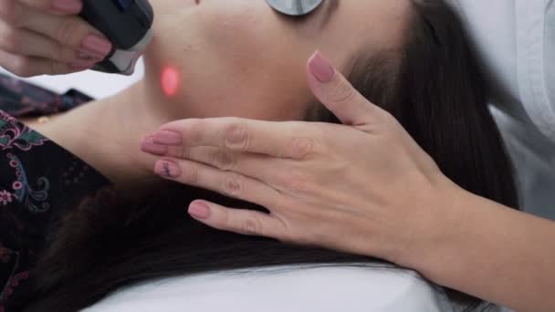 Close-up cosmetologist makes laser treatment to young woman face, removal of acne, slow motion — Stock Video