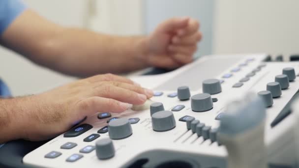 Las manos cercanas del médico trabajan con el escáner de ultrasonido, presiona los botones en la herramienta de diagnóstico especial — Vídeo de stock