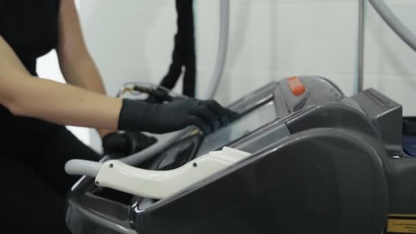 Крупним планом лікарі руки в рукавичках вмикають лазерне обладнання перед процедурою, повільний рух . — стокове відео