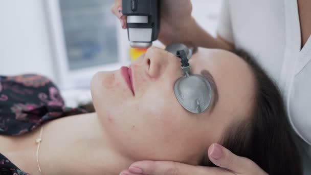 Il cosmetologo di primo piano fa la procedura di rimozione laser di capelli a faccia di donna giovane a clinica, il movimento lento — Video Stock