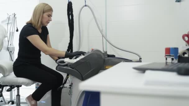 Cosmetologue allume l'équipement médical spécial avant la procédure dans le centre de beauté, au ralenti — Video