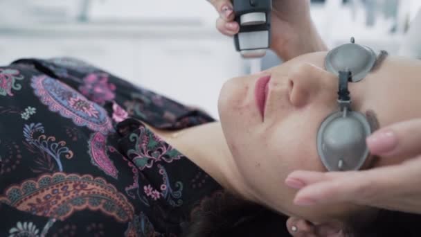 O cosmetologist close-up faz o tratamento do laser à cara nova da mulher, remoção da acne, câmera lenta — Vídeo de Stock