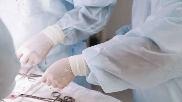 Close up hands of assistant, doctor hands use medical instruments during surgery, clamp, cotton swab — Stock Video