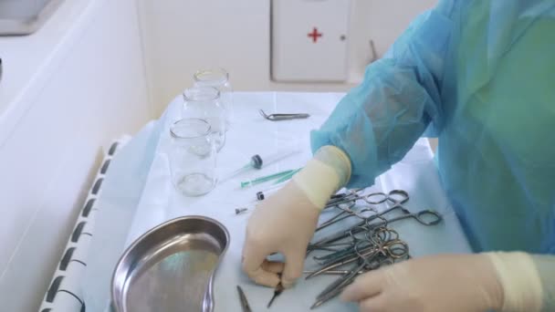Mãos de enfermeira close-up em luvas estéreis prepara instrumentos médicos para cirurgia de escleroterapia — Vídeo de Stock