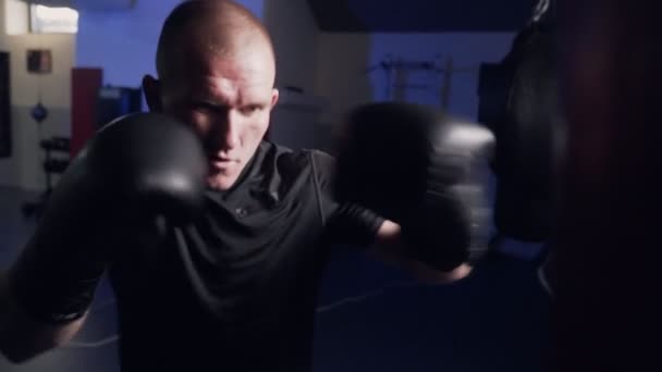 Boxer träna blåser på en slagsäck i slow motion, skaka kameran från att slå. — Stockvideo