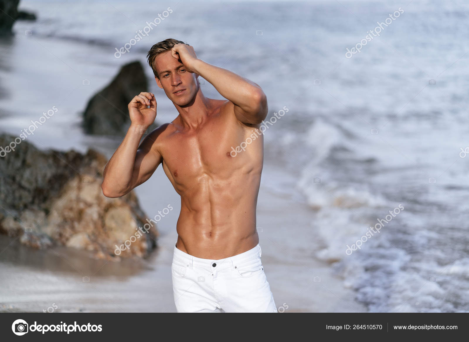 Beautiful man with naked muscular torso at white sand beach. Stock Photo by ©rmano.mail.ru 264510570
