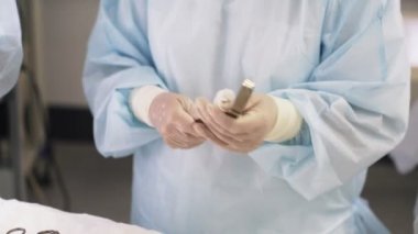 Eldiven dezenfekte hemşirenin ellerini kapatın, ameliyat sırasında tıbbi cihazlardan kan siler