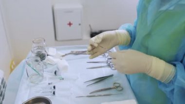 Steril eldivenlerde yakın çekim hemşire elleri skleroterapi cerrahisi için tıbbi aletler hazırlar