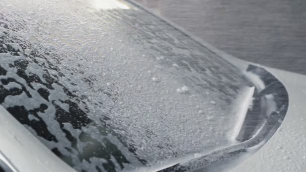洗车。发泡洗涤剂覆盖汽车的挡风玻璃，清洁汽车污垢。慢动作 — 图库视频影像