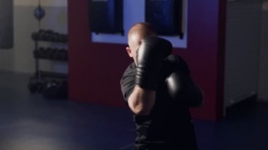 Boks eldivenleri ile Boksör spor salonunda kamera darbeler dışarı çalışma, gölge mücadele, yavaş hareket.