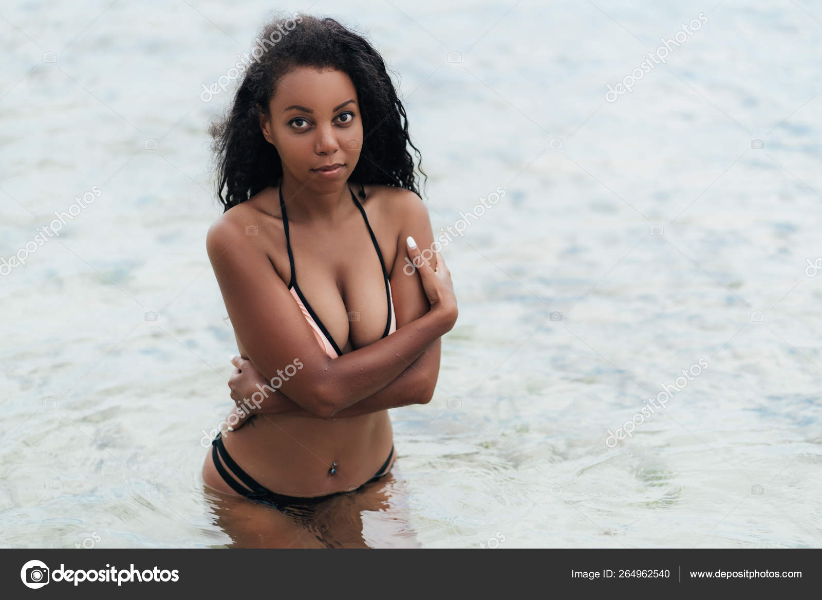 Portrait of sexy dark skinned Afro american girl with big breasts on beach.  Stock Photo by ©rmano.mail.ru 264962540