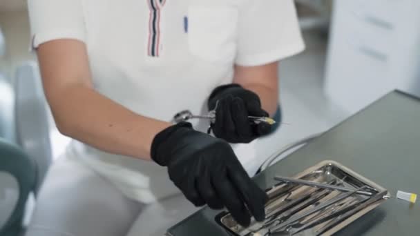 Fechar as mãos do dentista prepara a seringa com anestésico antes do tratamento dentário, câmera lenta — Vídeo de Stock