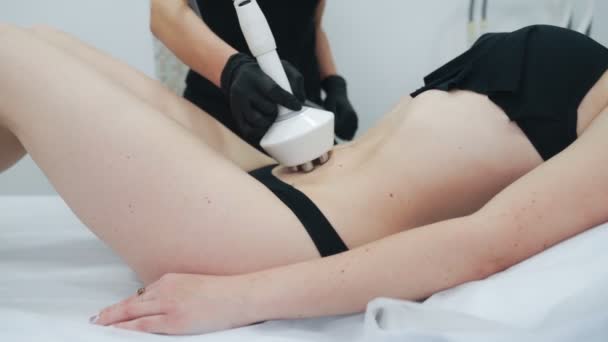 Primer plano esteticista manos hace rf-lifting procedimiento en joven mujer estómago, cámara lenta — Vídeos de Stock