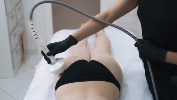 Закройте руки косметолога делает антицеллюлитную процедуру для молодой женщины, замедленная съемка — стоковое видео