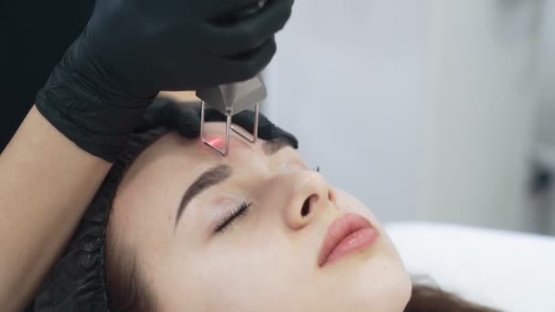 Le mani di cosmetologo di movimento lento fanno a peeling facciale di ragazza con dispositivo speciale — Video Stock