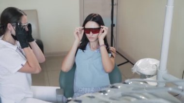 Diş hekimi ve hasta diş kliniğinde koruyucu gözlük taktılar, yavaş hareket. Komik video