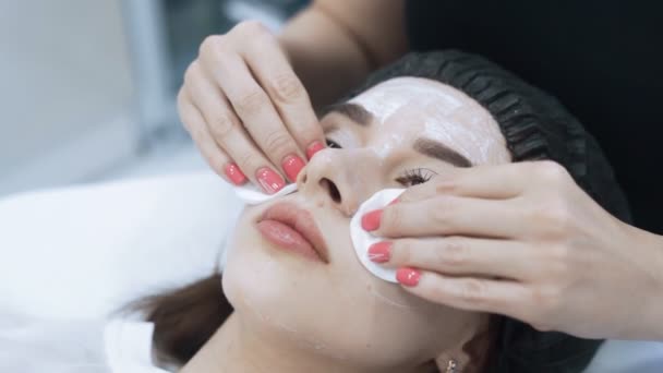 Закрыть лицо красивой девушки делает косметическую процедуру в салоне красоты, замедленной съемки — стоковое видео