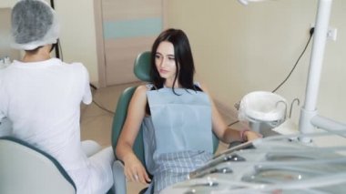 Diş hekimi hasta dişlerini incelemek için diş aletleri alır, yavaş hareket