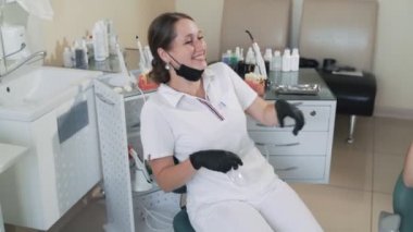 Diş hekimi güler ve diş kliniğinde hasta ile gülümsüyor, yavaş hareket. Komik video