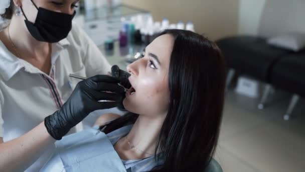 Dentista examina os dentes do paciente com ferramentas dentárias, câmera lenta. Mulher no consultório odontológico . — Vídeo de Stock