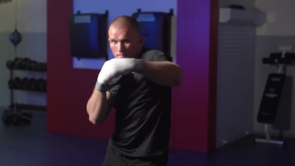 Boxeador entrena golpes en el gimnasio, cámara lenta. Combatiente practicando lucha con sombra — Vídeo de stock