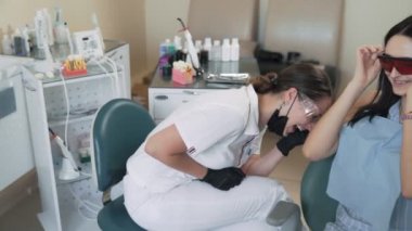 Diş hekimi ve hasta kadın gülmek ve diş kliniğinde gülümseme, yavaş hareket. Komik video