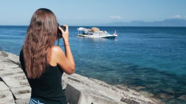 Vista laterale del fotografo ragazza scatta foto di barca sulla macchina fotografica professionale — Video Stock