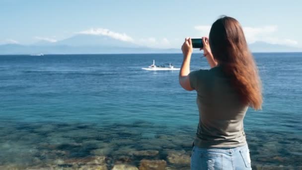 Rückseite von Mädchen Reisenden macht Video am Telefon, wie Boot schwimmt, Zeitlupe — Stockvideo