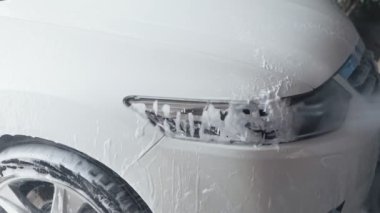 Araba yıkama işlemi. Yüksek basınçlı su jeti arabayı kirliden temizleyin. Yavaş çekim 