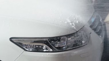 Araba yıkama işlemi. Yüksek basınçlı su jeti arabayı kirliden temizleyin. Yavaş çekim 