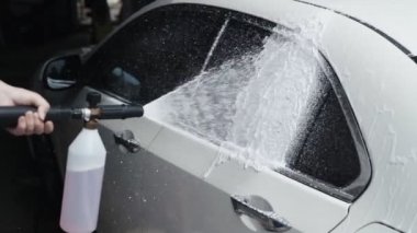 Yakın işçi elleri makineye deterjan uygulayın. Araba yıkama işlemi. Yavaş çekim