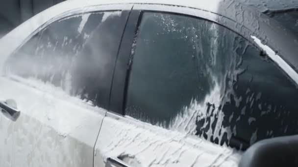 Processo de lavagem de carro. Espuma detergente cobre a máquina, limpa-a da sujeira. Movimento lento — Vídeo de Stock