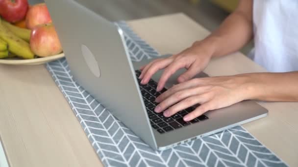 Закройте руки женщины, печатающие на клавиатуре ноутбука, замедленная съемка. Девушка работает на компьютере — стоковое видео
