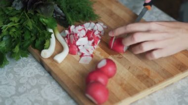 Ahşap tahta üzerinde bıçak kesme turp ile kadın ellerini kapatın. Konsept sebze