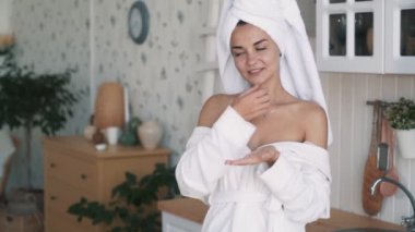 Bornozgüzel kız yakın boyun, omuz, yavaş hareket krem uygular