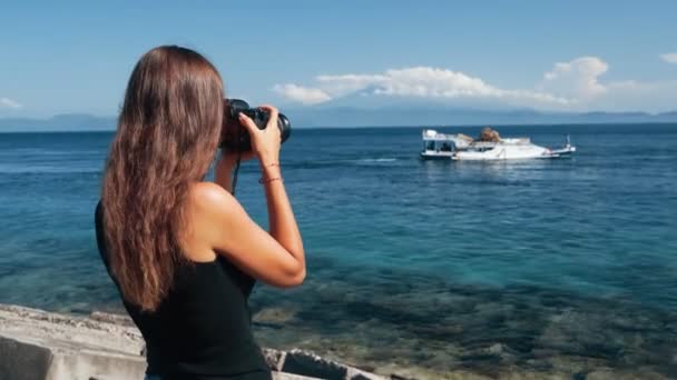 Боковой вид девушки фотограф делает фото лодки на профессиональную камеру — стоковое видео