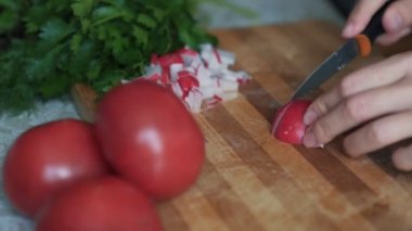 Ahşap tahta üzerinde bıçak dilimleme turp ile kadın ellerini kapatın. Konsept sebze