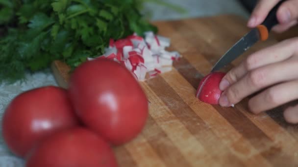 Chiudi le mani donna con coltello affettare ravanelli su tavola di legno. Concetto vegetale — Video Stock