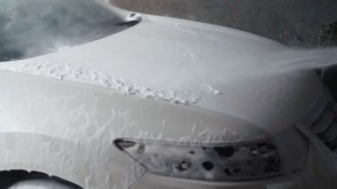 Araba yıkama işlemi. Yüksek basınçlı su jeti arabayı kirliden temizleyin. Yavaş çekim 