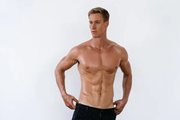 Portrait of sexy athletic man with naked torso poses on white background. — Stock Photo, Image