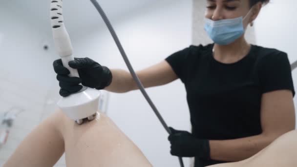 Beautician does anti cellulite procedure on patient legs at clinic, slow motion — Stock Video