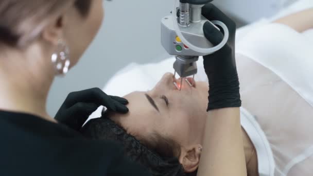 Slow Motion schoonheidsspecialiste doet Laser Facial peeling voor vrouw met speciaal apparaat — Stockvideo