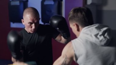 Koç spor salonunda boksör trenler, tekme ve savunma, yavaş hareket dışarı çalışmak.