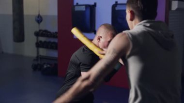 Koç spor salonunda boksör trenler, tekme ve savunma, yavaş hareket dışarı çalışmak.