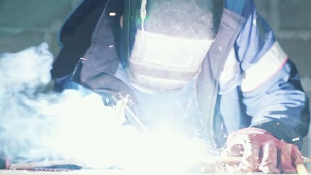 Close-up, lasser lasnaden twee metalen onderdelen. Workman in overall werkt binnenshuis, slow-motion — Stockvideo