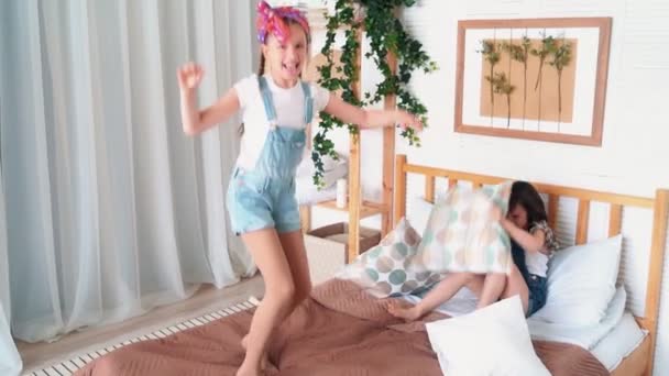 Deux petites filles mignonnes jouent sur le lit, combat d'oreiller, ralenti — Video