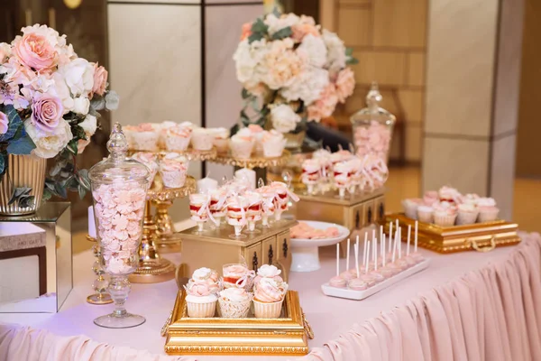 Candy bar on table in vase and plate, macaroon, marshmallow, cake and ccake — стоковое фото